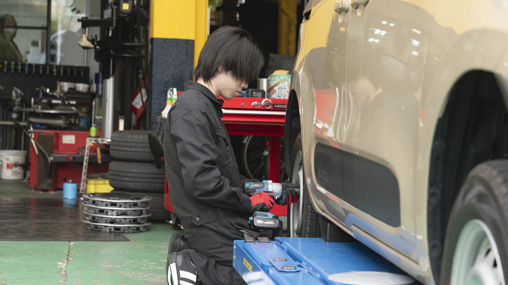 リフトに上げた車のタイヤを交換する様子