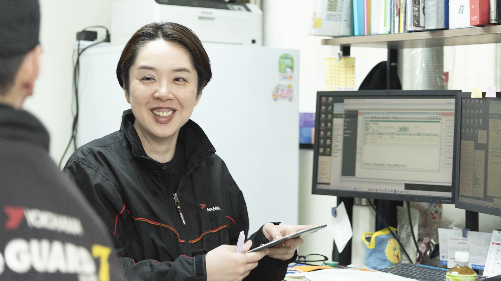 事務所でパソコンを使って受付対応をするスタッフ