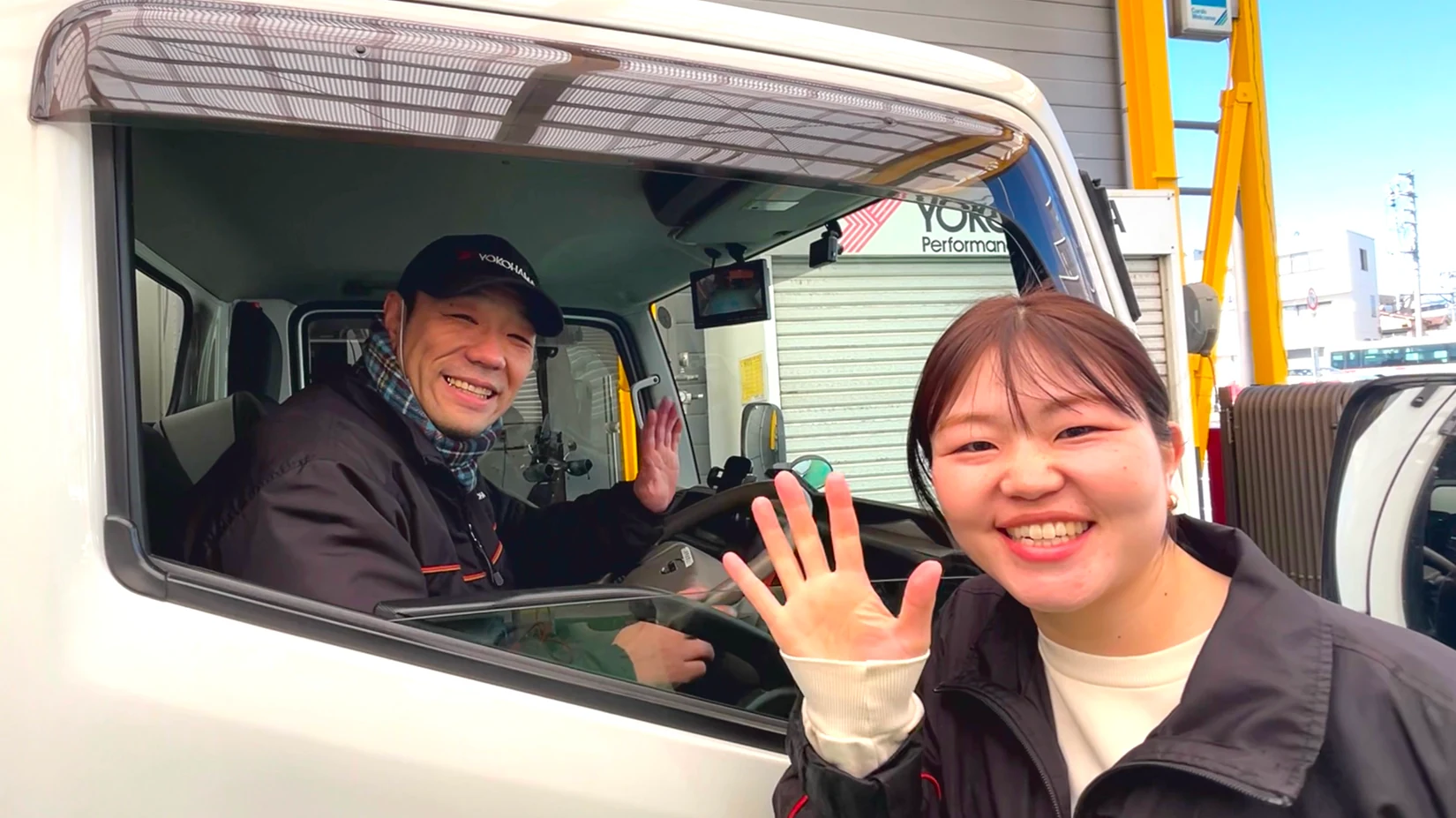 作業を終えたお客様の車を見送るスタッフ